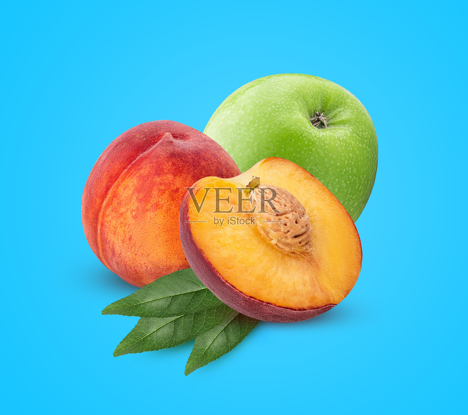 熟透的桃果切成两半,带骨、绿叶和青苹果照片摄影图片