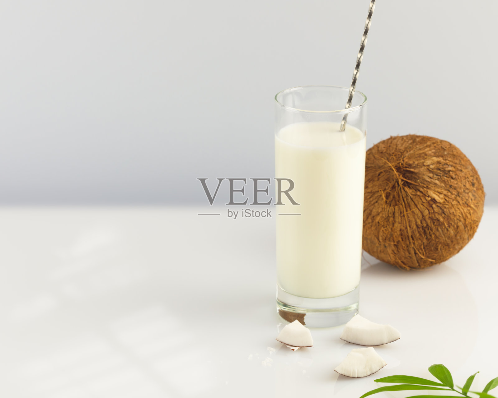 一杯含椰子和棕榈叶的椰奶照片摄影图片