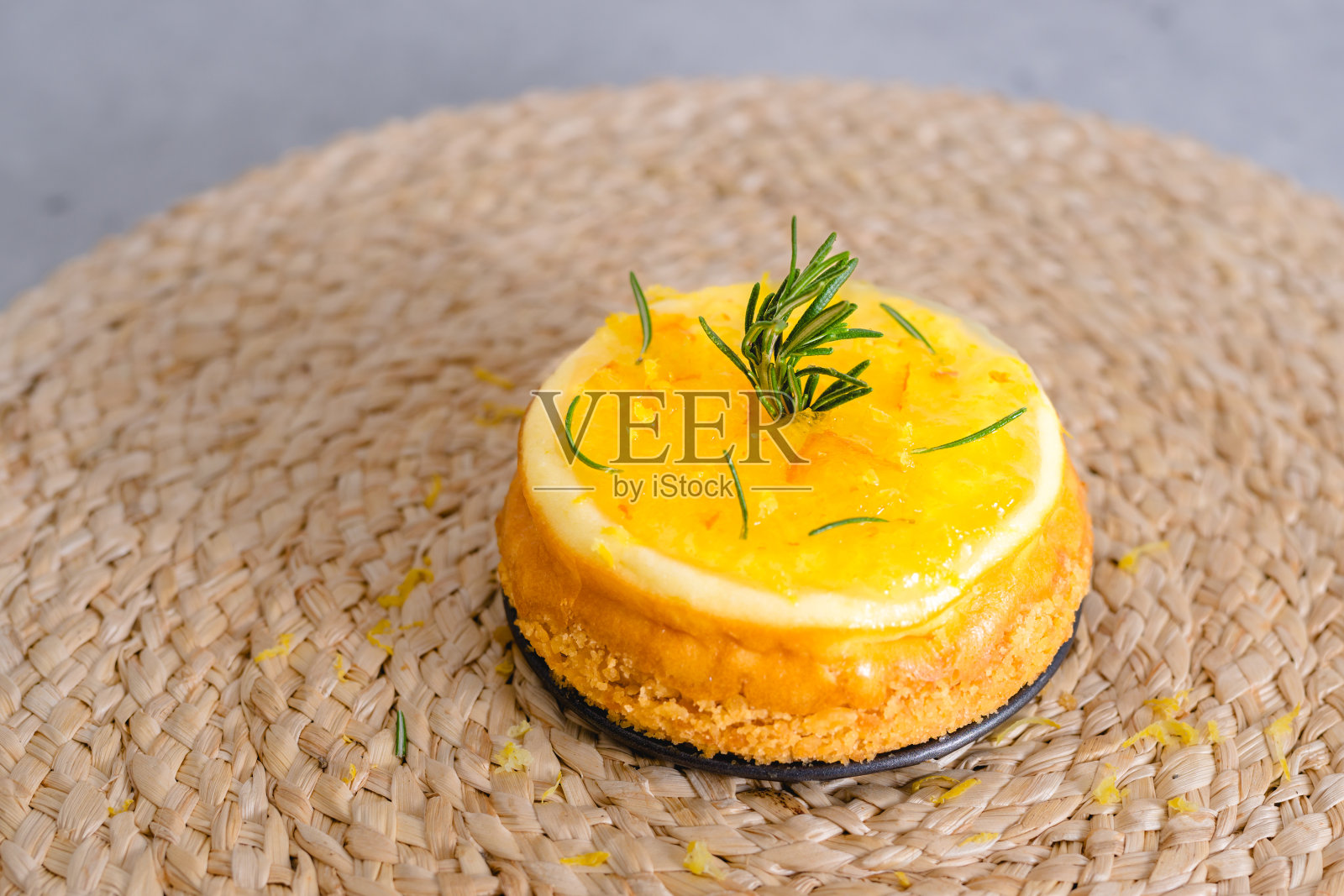 迷你芝士蛋糕配橘子果冻和迷迭香特写放在厨房桌子上。美味的甜点,甜与浓烈的味道完美结合照片摄影图片