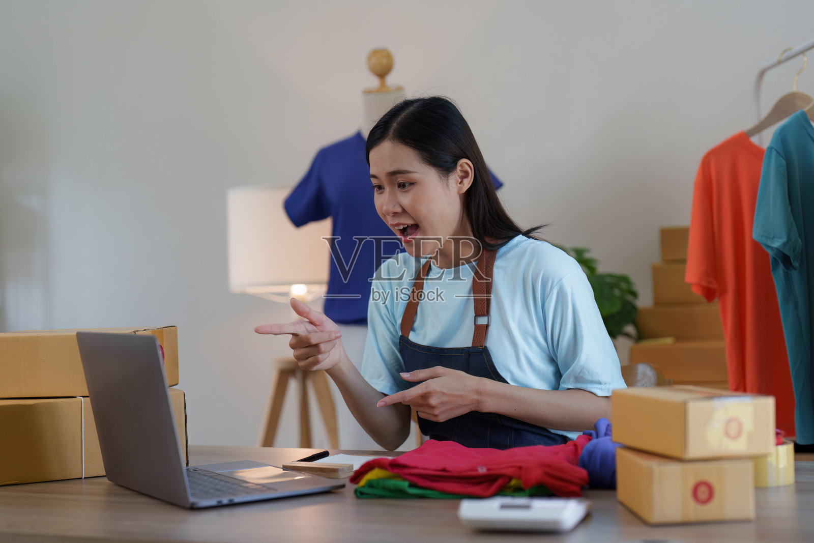 亚洲女性时装设计师布裁缝创意工作的新系列。快乐的网上商店老板准备运输订单照片摄影图片