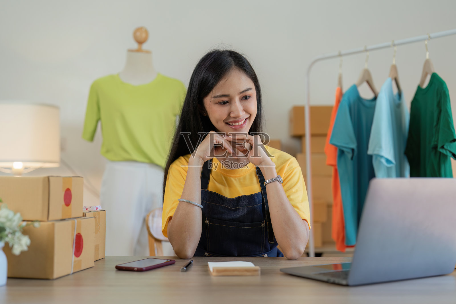 亚洲女性时装设计师布裁缝创意工作的新系列。快乐的网上商店老板准备运输订单照片摄影图片