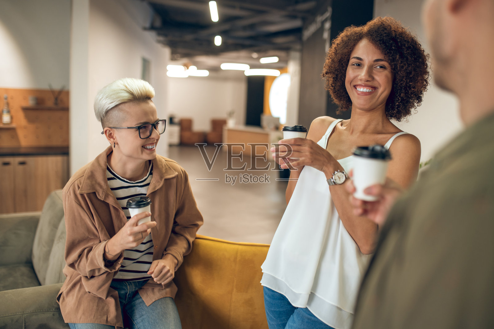 两位女职员正在享受与同事的交流照片摄影图片