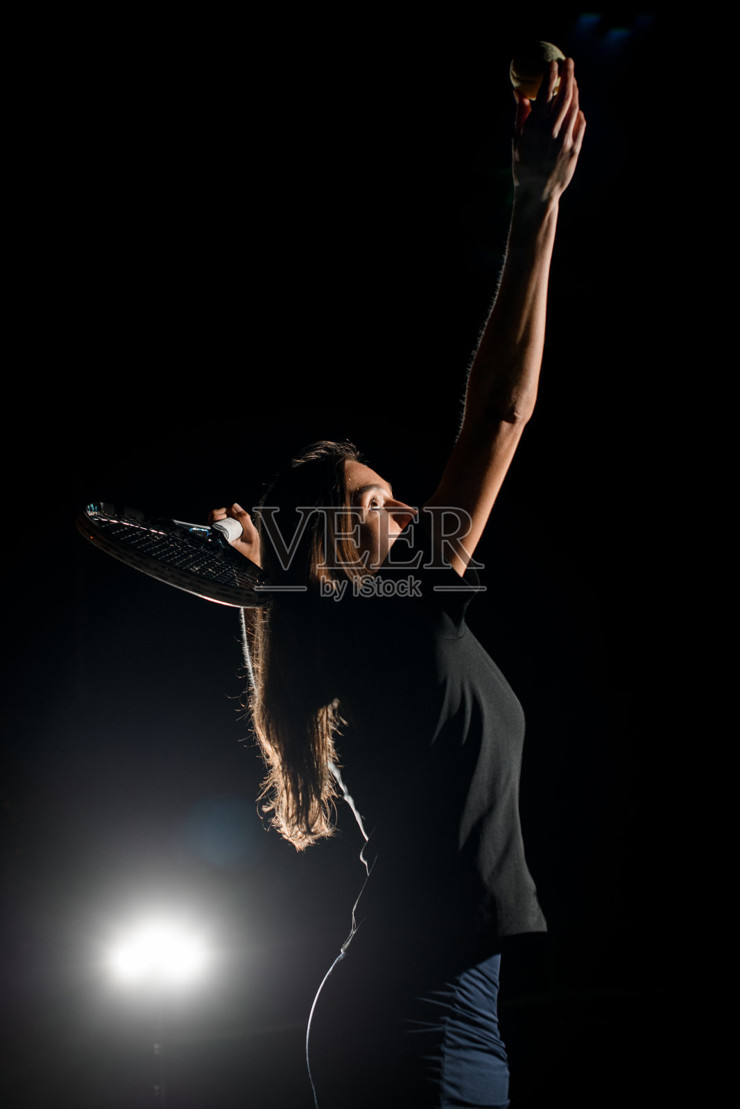 女网球运动员与她的手臂举起网球的近景照片摄影图片