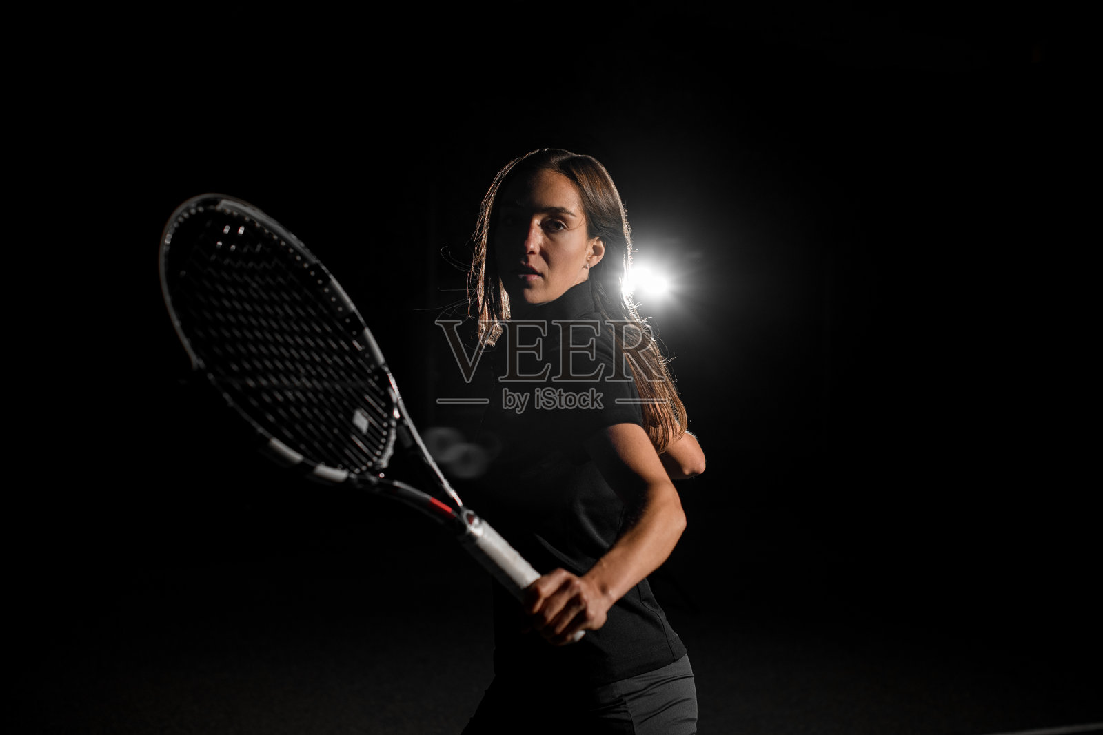 美丽的肖像积极的女网球运动员与球拍。暗的背景照片摄影图片