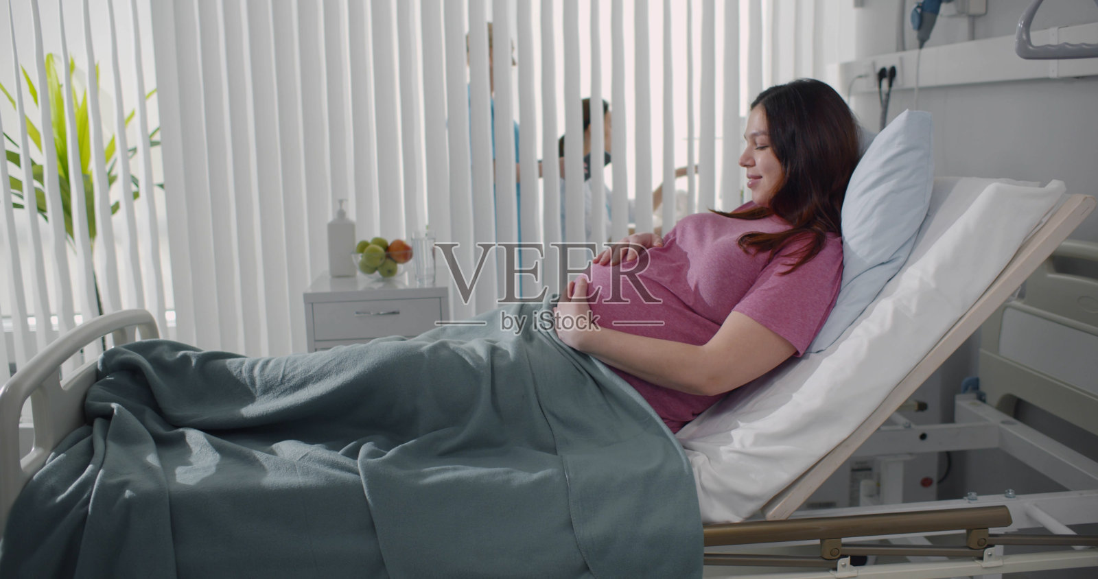怀孕的年轻妇女躺在产房的床上照片摄影图片