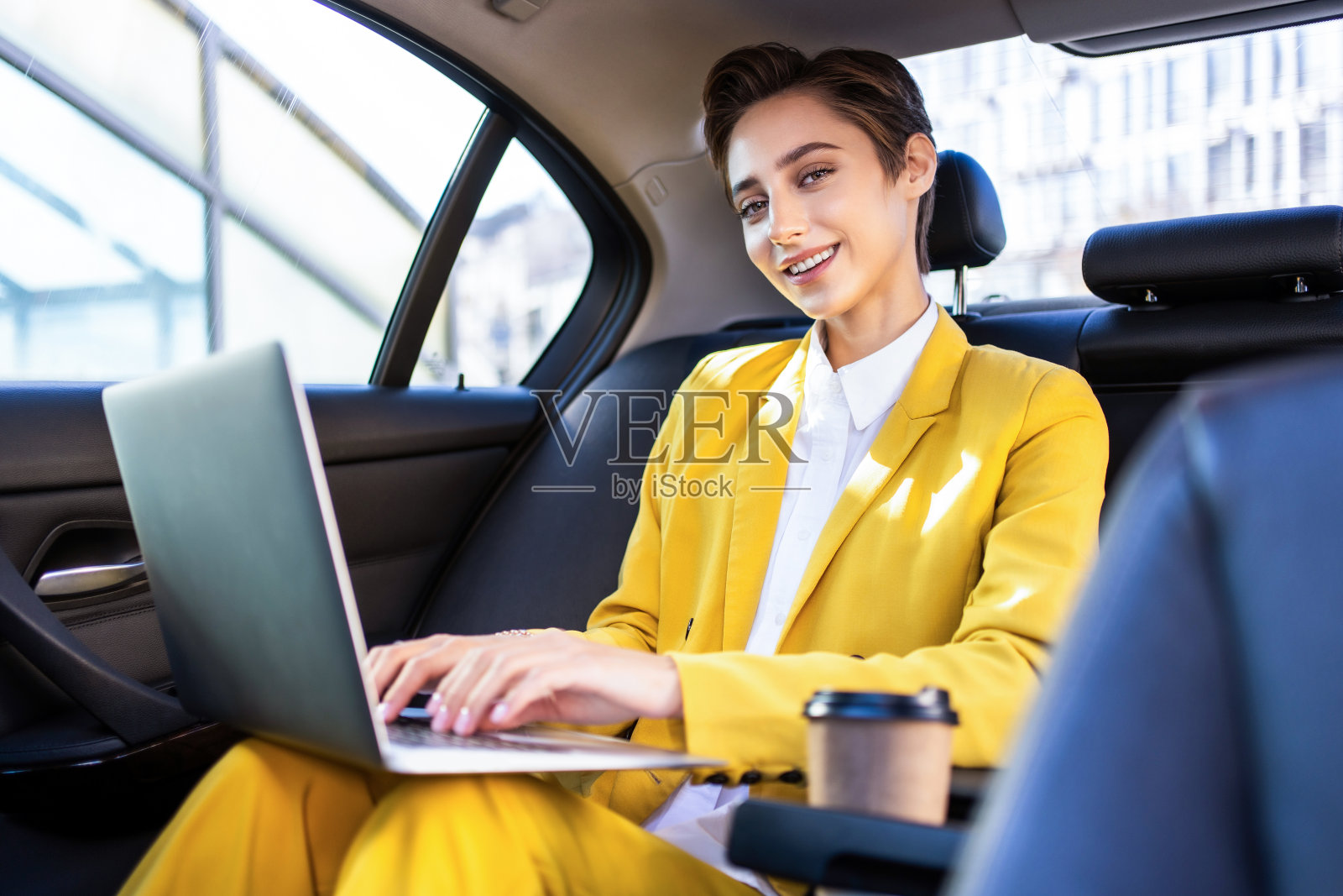 年轻漂亮的短发女子在城市里开车照片摄影图片