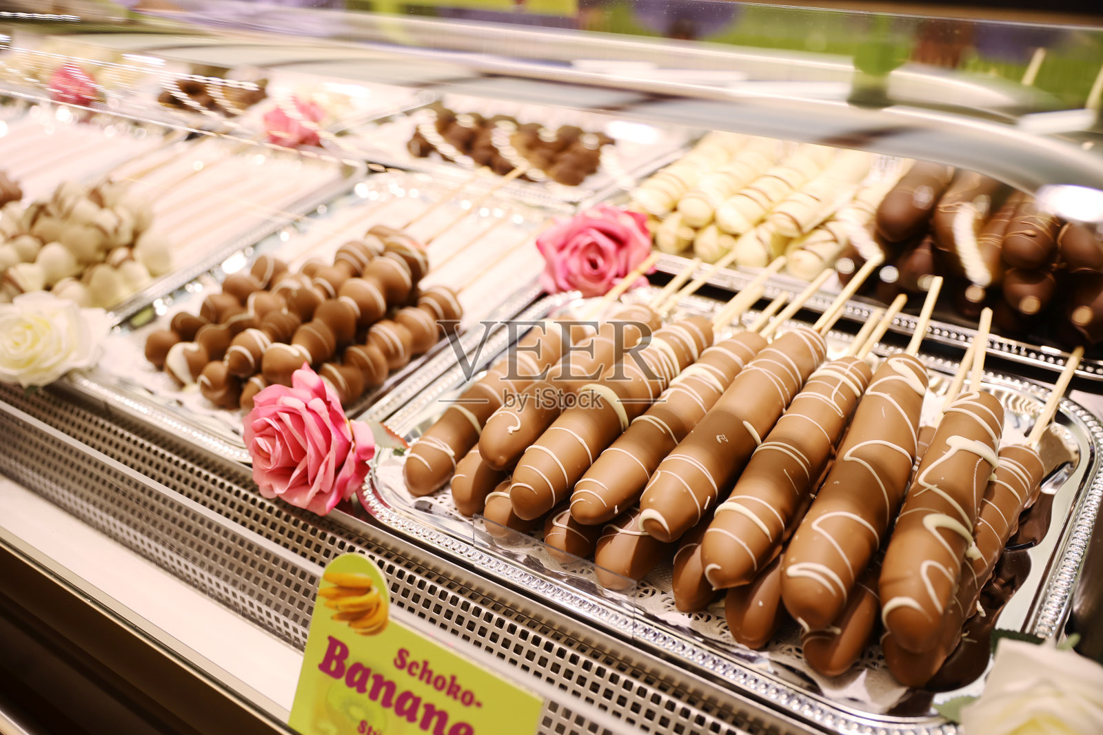 巧克力火锅配新鲜香蕉。奶酪火锅配融化的巧克力和香蕉。在德国圣诞市场上,水果摊上出售的香蕉串和融化的巧克力棒照片摄影图片