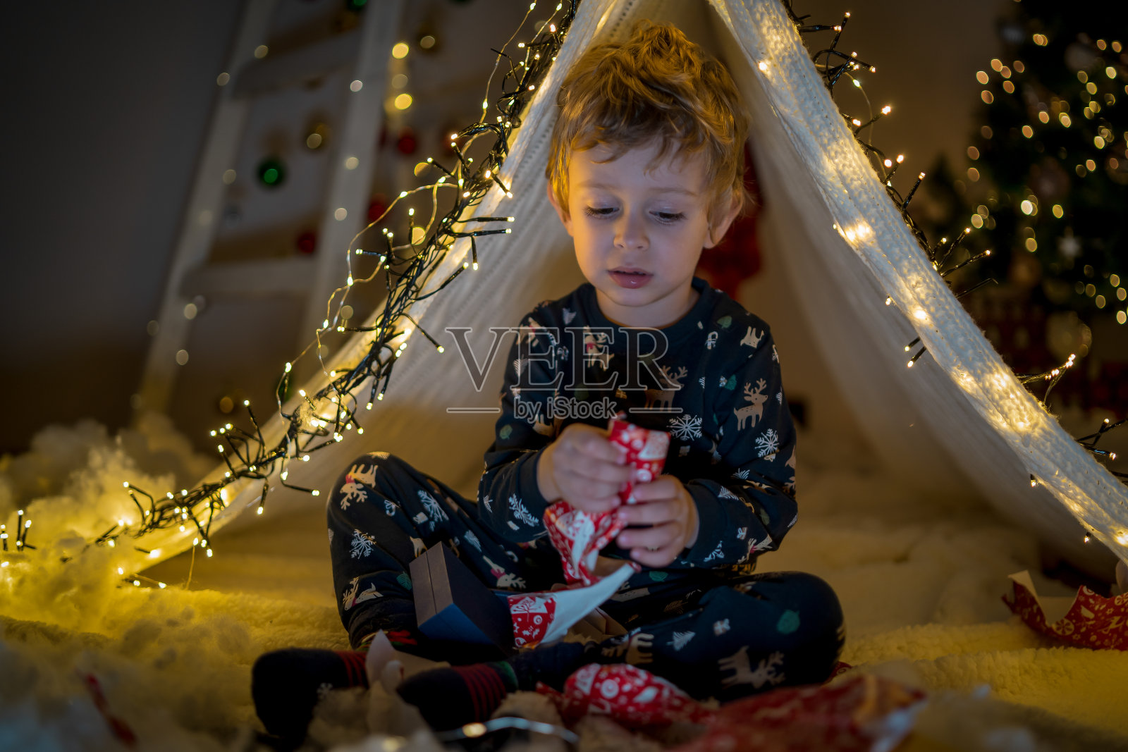 圣诞假期,穿着睡衣的孩子在家里玩着发光的帐篷照片摄影图片