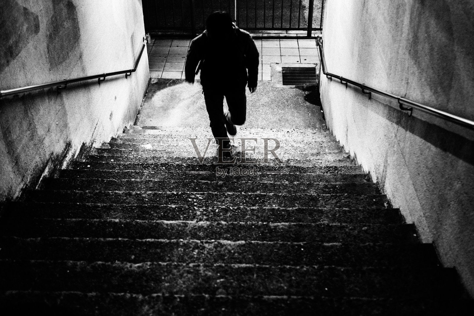 一个人的剪影从地下通道跑上楼梯到地面照片摄影图片