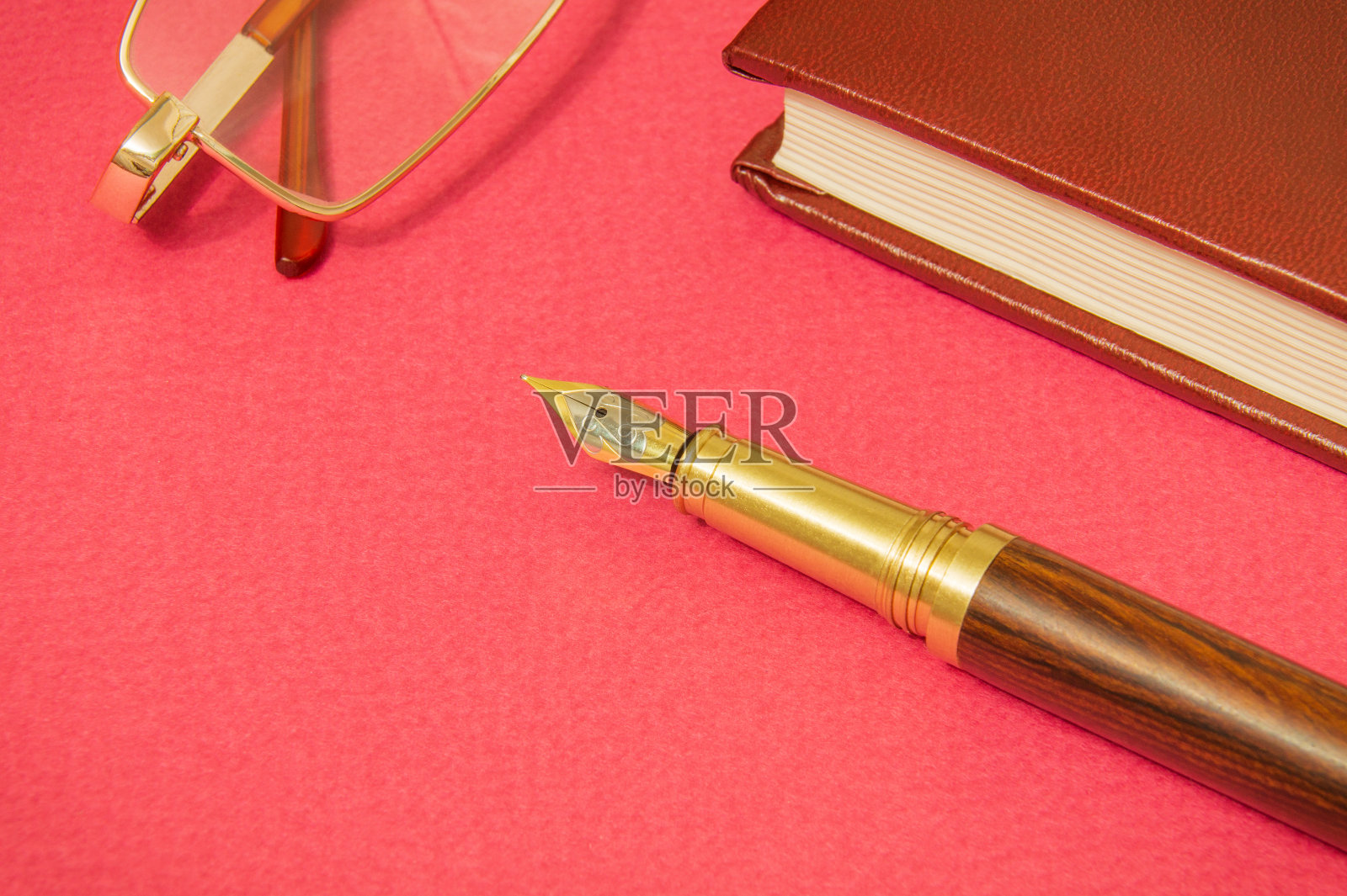 办公室静物生活红色的桌子上有笔记本,金毛笔和眼镜商人准备的笔记照片摄影图片