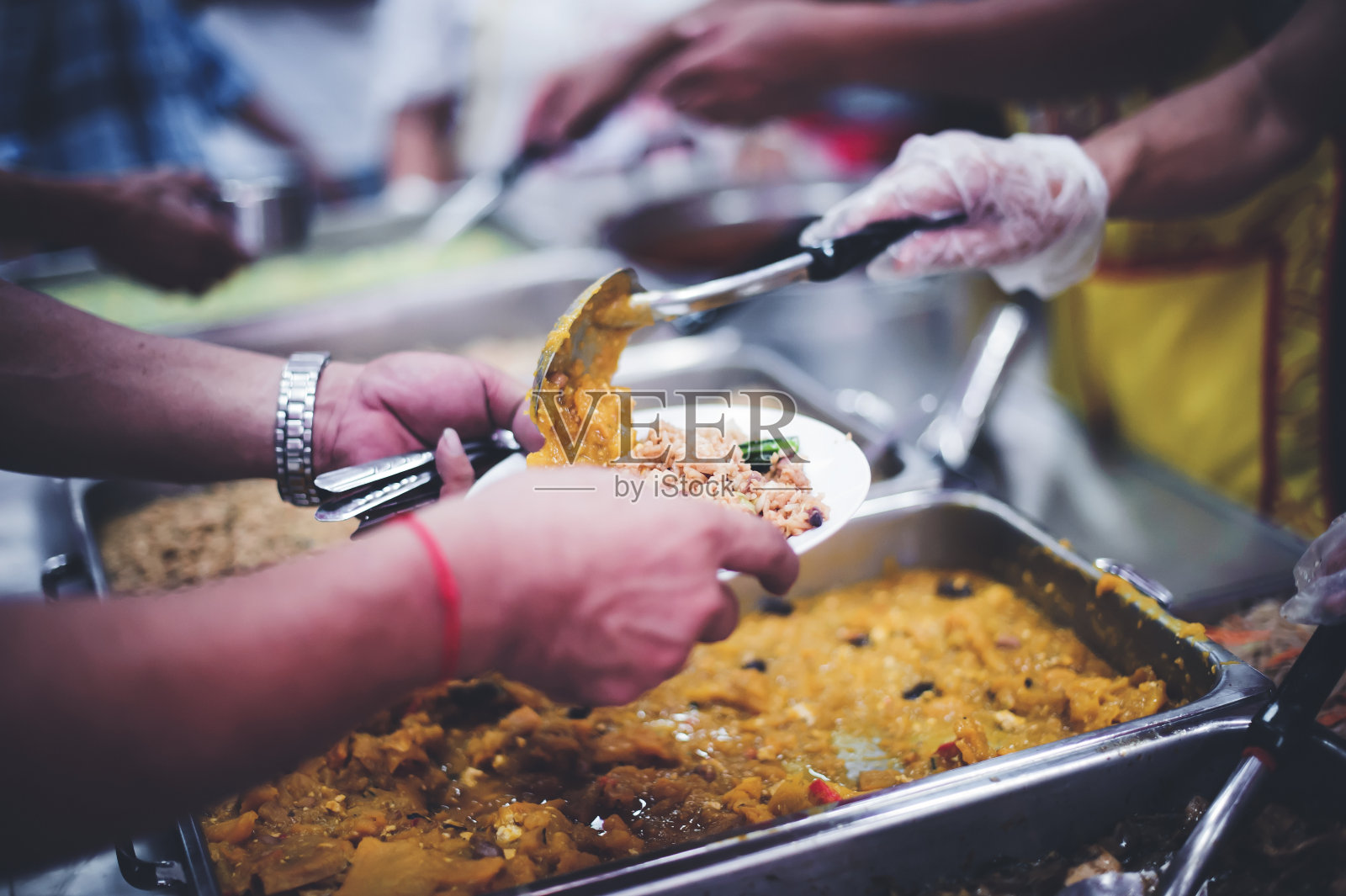 给无家可归的人免费食物。志愿者为清迈的饥饿和无家可归者提供食物照片摄影图片