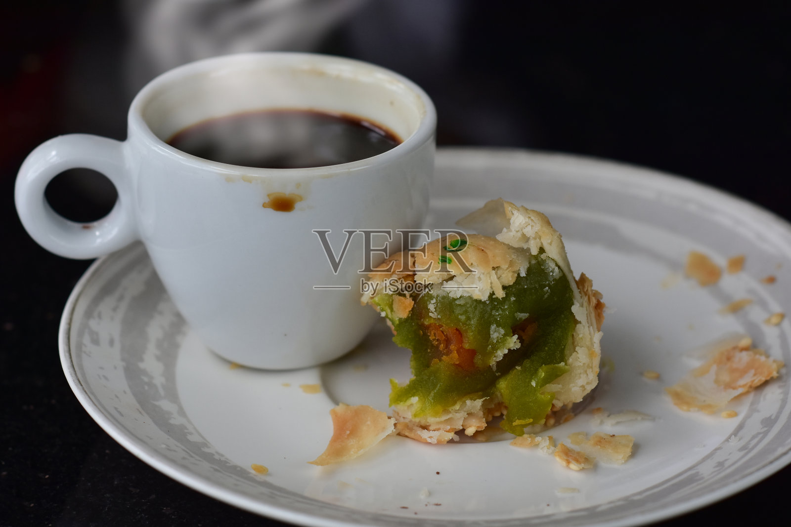 咖啡就是把一杯热气腾腾、烟雾缭绕的咖啡倒在地上。照片摄影图片