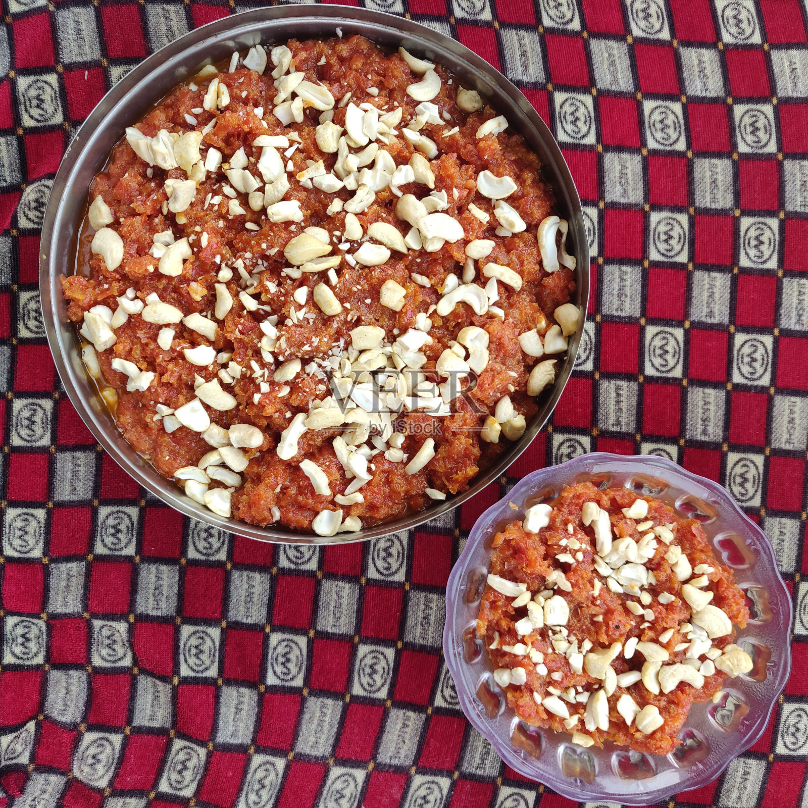 顶部视图的加贾尔哈尔瓦与胡萝卜,腰果,开心果在碗上的格子背景照片摄影图片