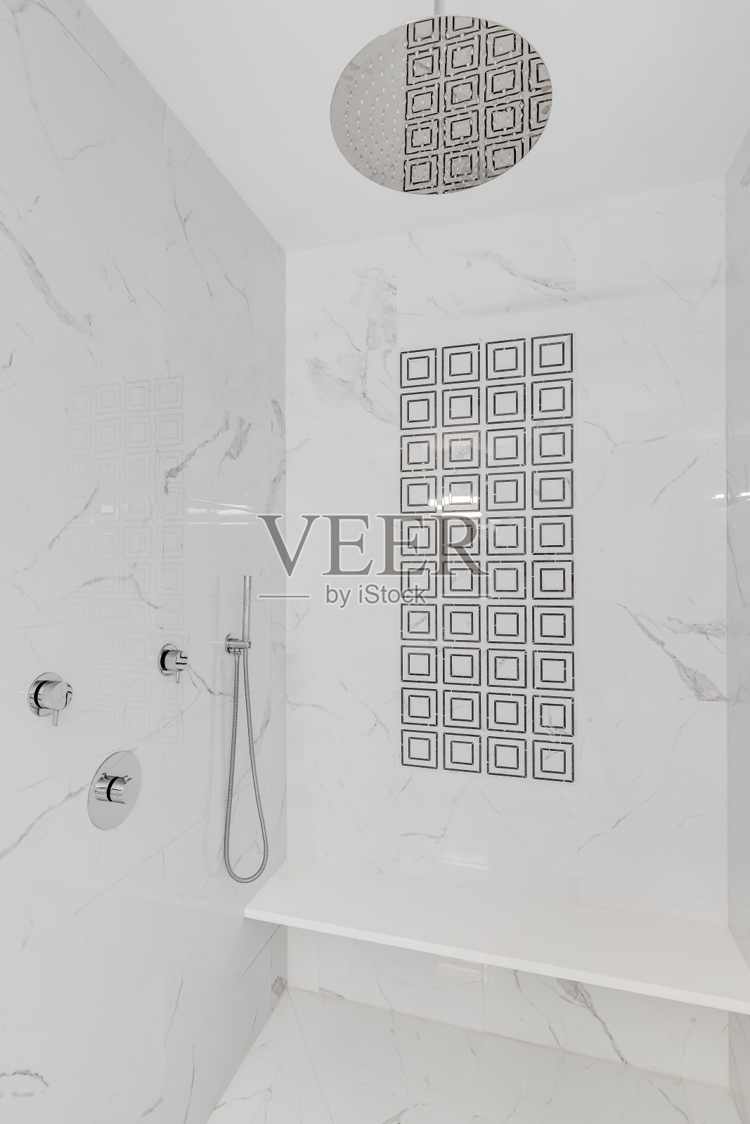 大理石瓷砖的豪华步入式淋浴间。照片摄影图片