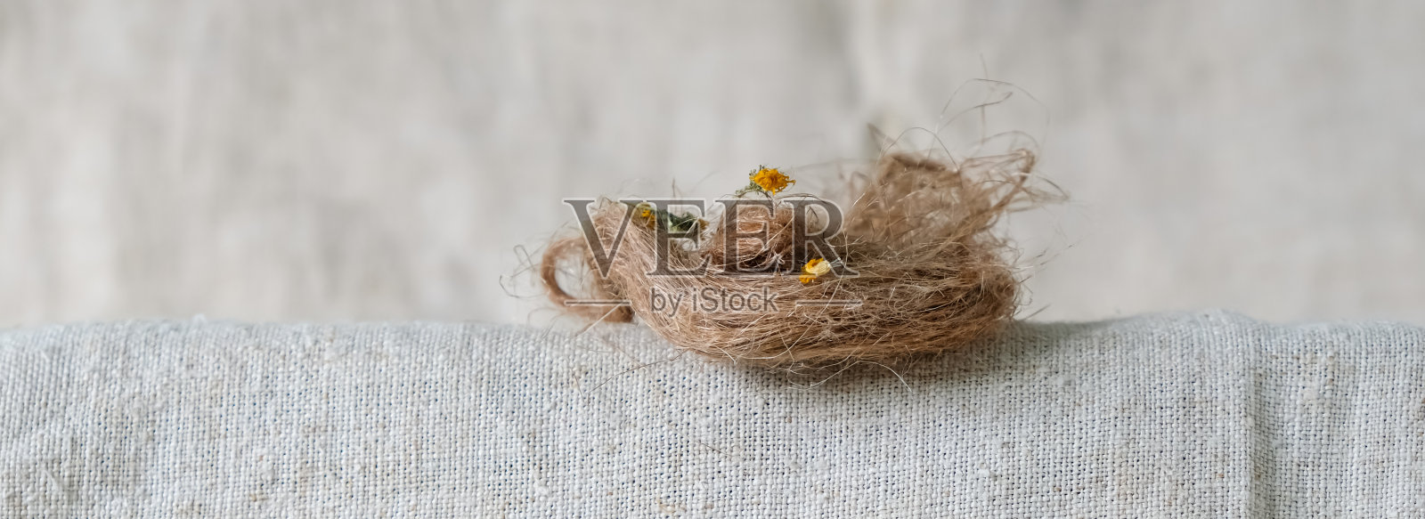 麻桌布上的天然麻束或亚麻束。干燥的黄花。照片摄影图片