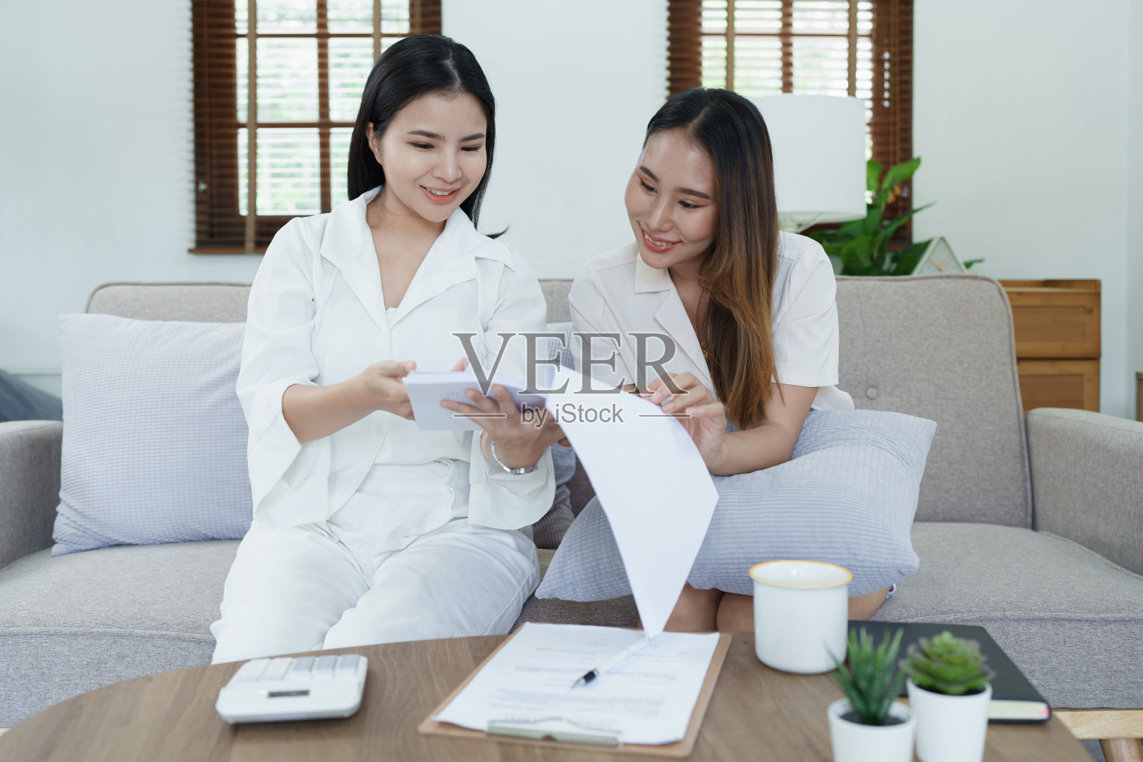 年轻的亚洲女性代理人肖像提供人寿保险客户使用文件,计算器和平板电脑在产品介绍照片摄影图片