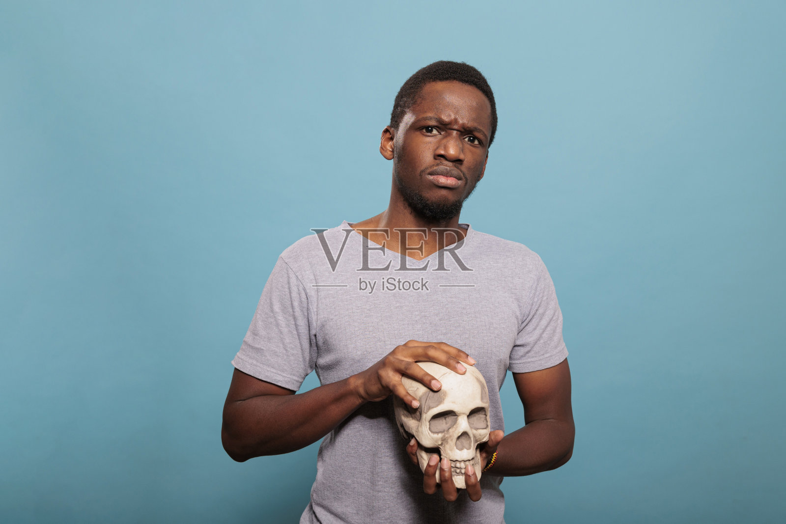 千禧年的人拿着骷髅的头骨照片摄影图片