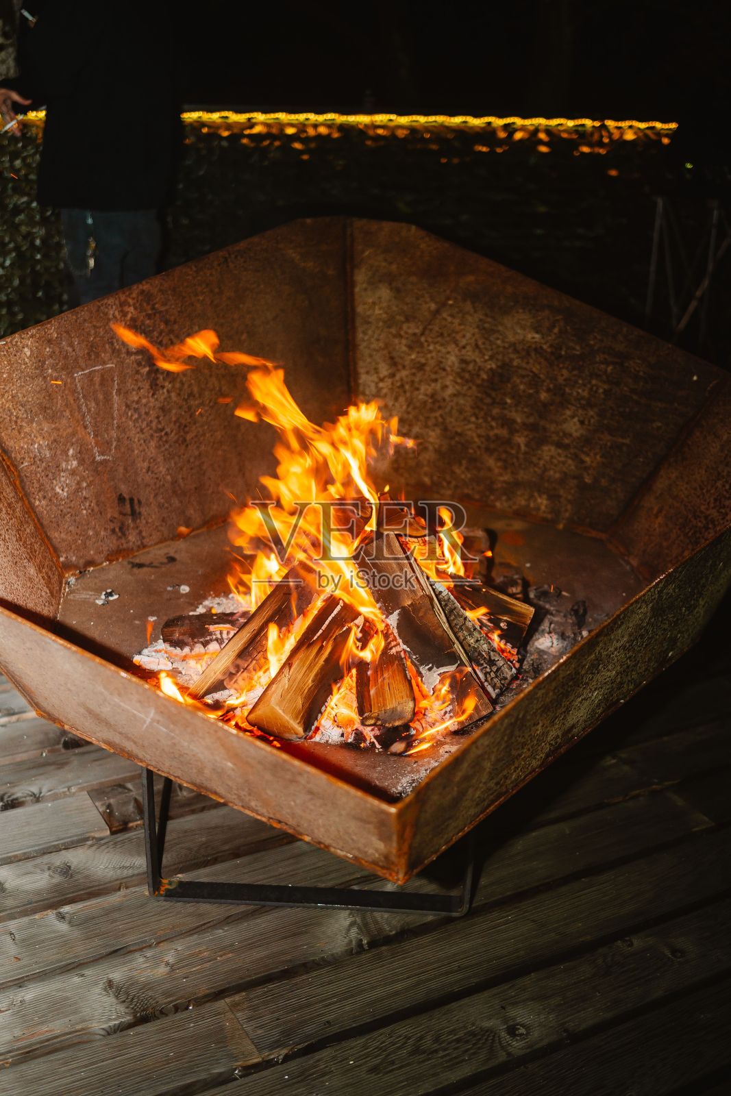 垂直拍摄在金属容器中燃烧的小篝火照片摄影图片
