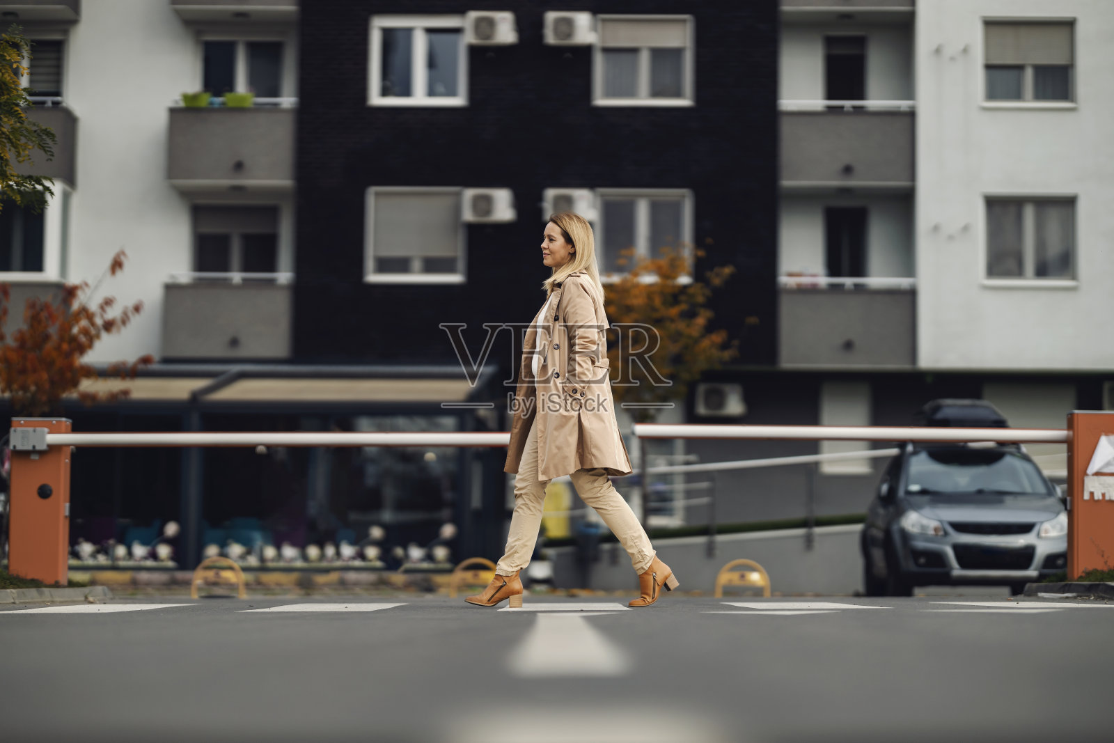 一个时髦的女人正在穿过城市街道上的十字路口。照片摄影图片