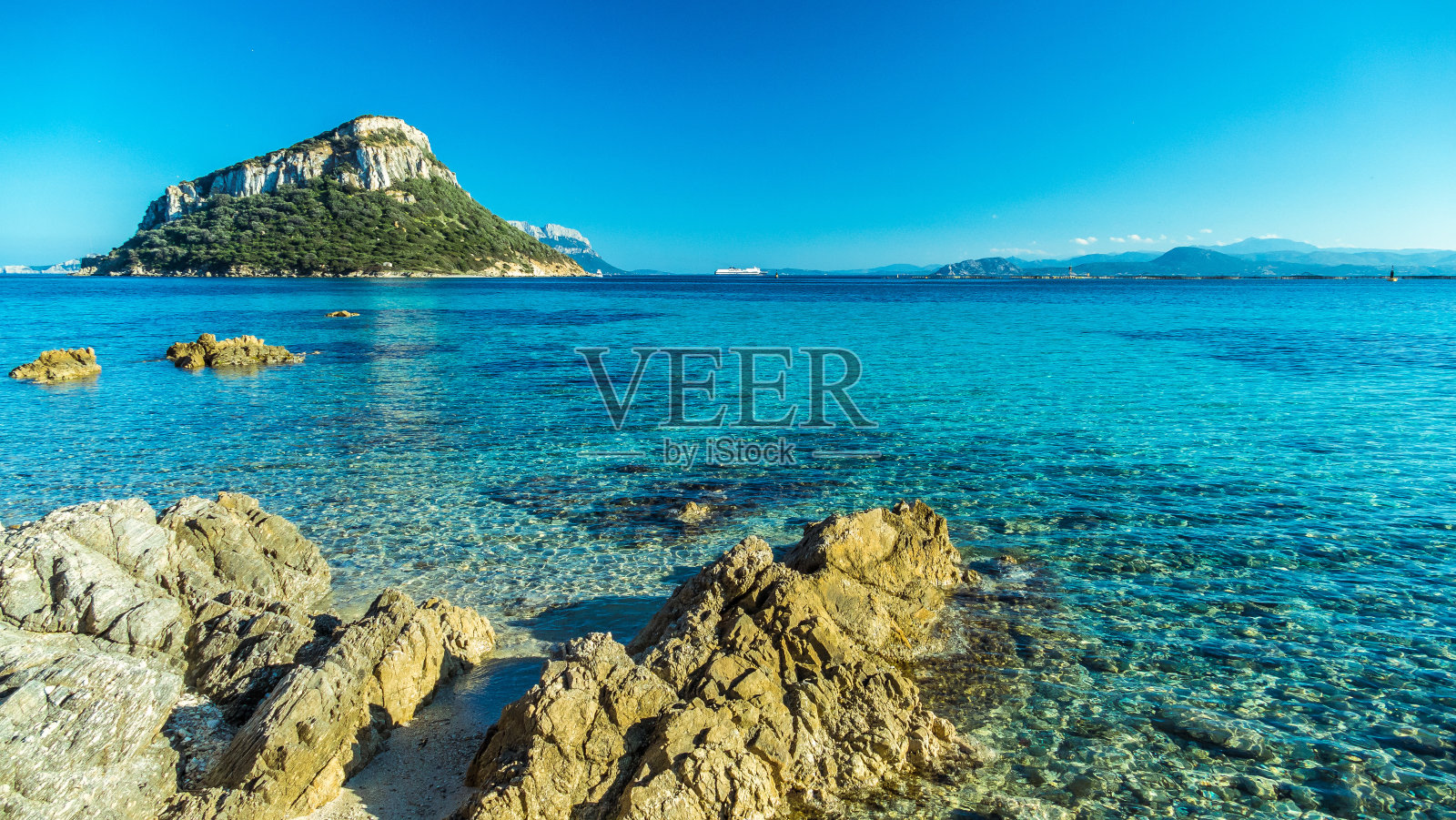 在撒丁岛,清澈的海水被岩石海岸包围照片摄影图片