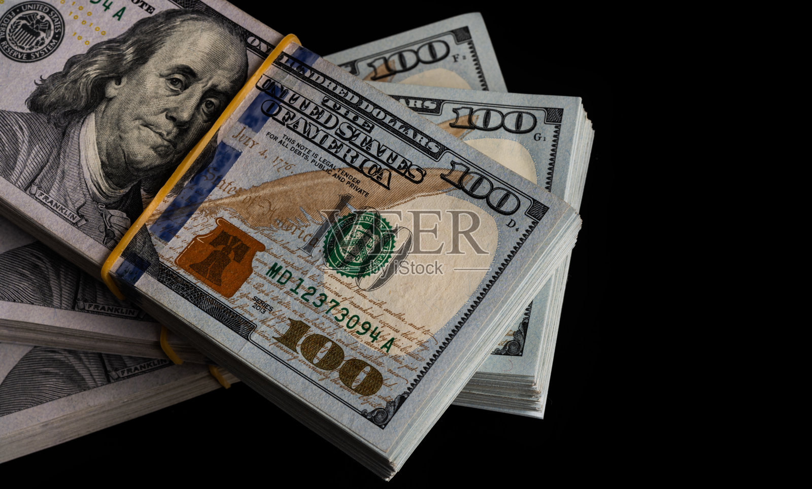 三捆黑色背景的100美元钞票照片摄影图片