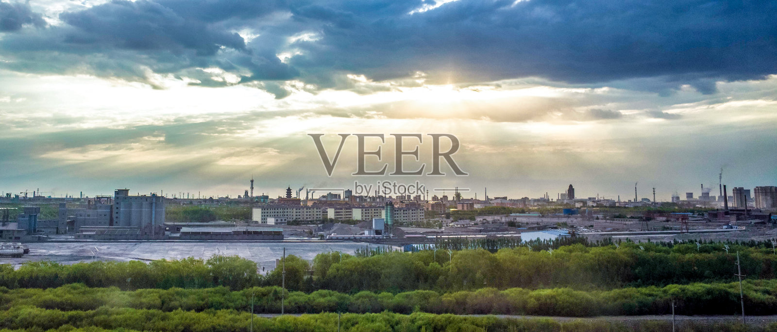 阳光穿透云层,照亮了城市的全景照片摄影图片