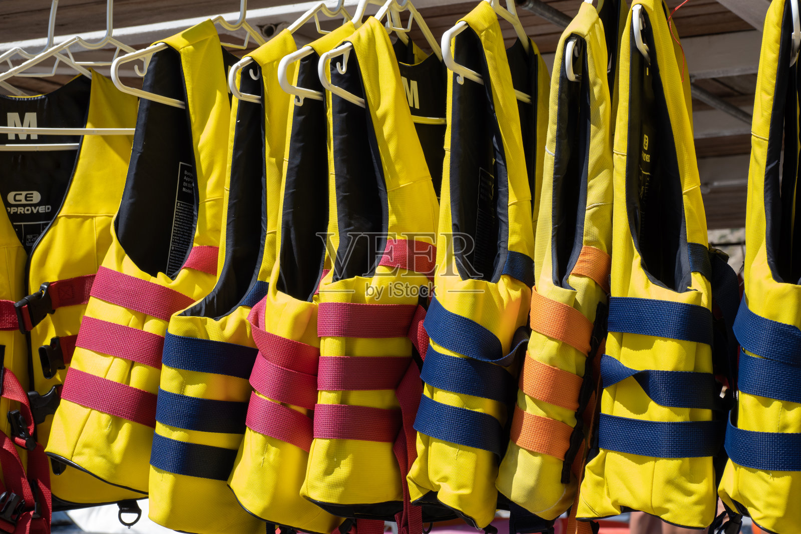 黄色救生衣挂在衣架上作为水上运动的概念照片摄影图片