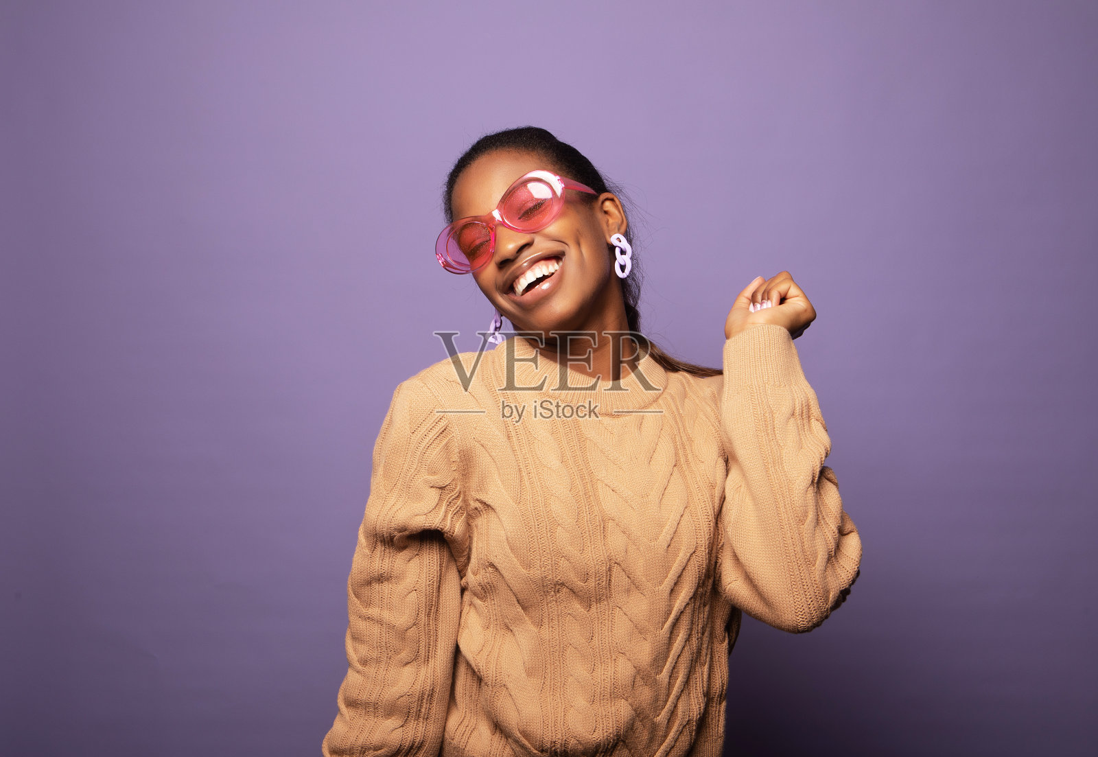 照片的可爱年轻的爆炸女人穿着米色毛衣跳舞孤立的紫色背景照片摄影图片