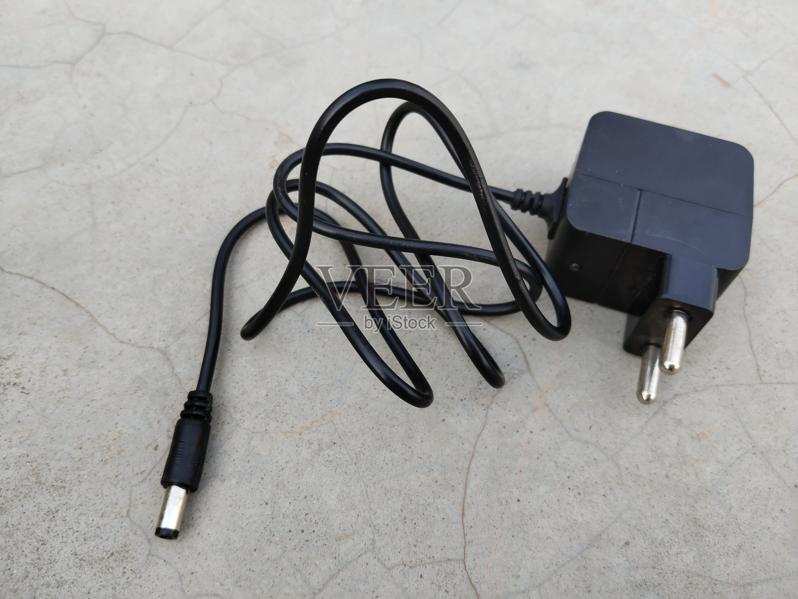 通用电源适配器,电源,交流适配器,直流电源,家用电器。
黑色电源线,地板上有欧洲插头。安装箱适配器照片摄影图片