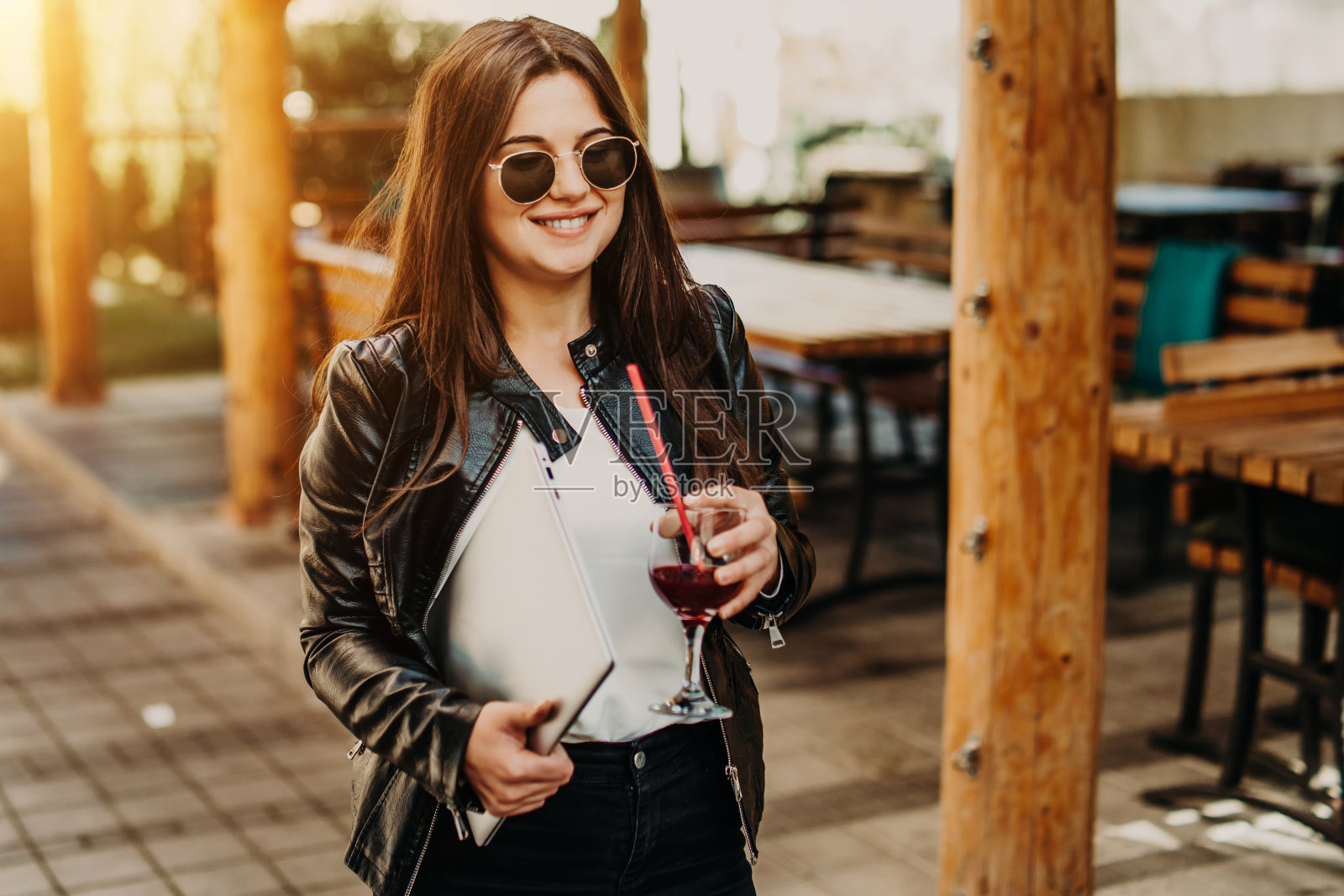 一个女商人拿着笔记本电脑走在街上照片摄影图片