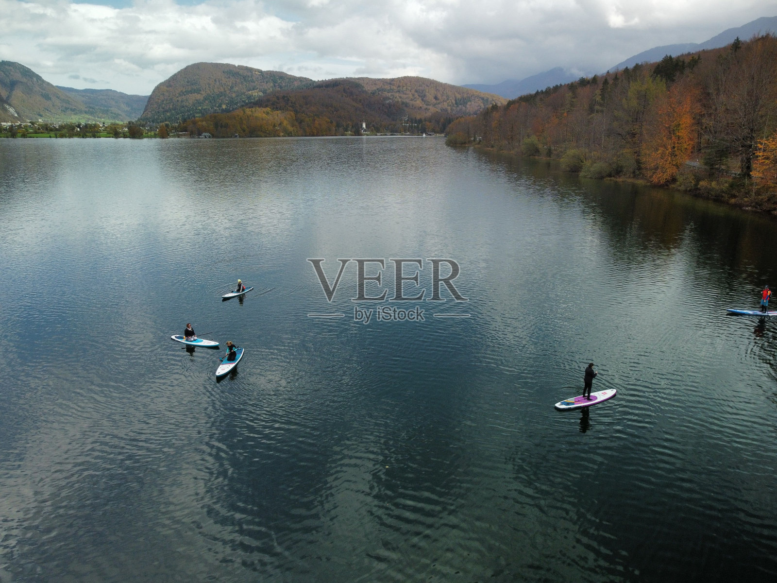 美丽的镜头,一个人在一个湖泊中划水,周围是秋天颜色的山丘照片摄影图片