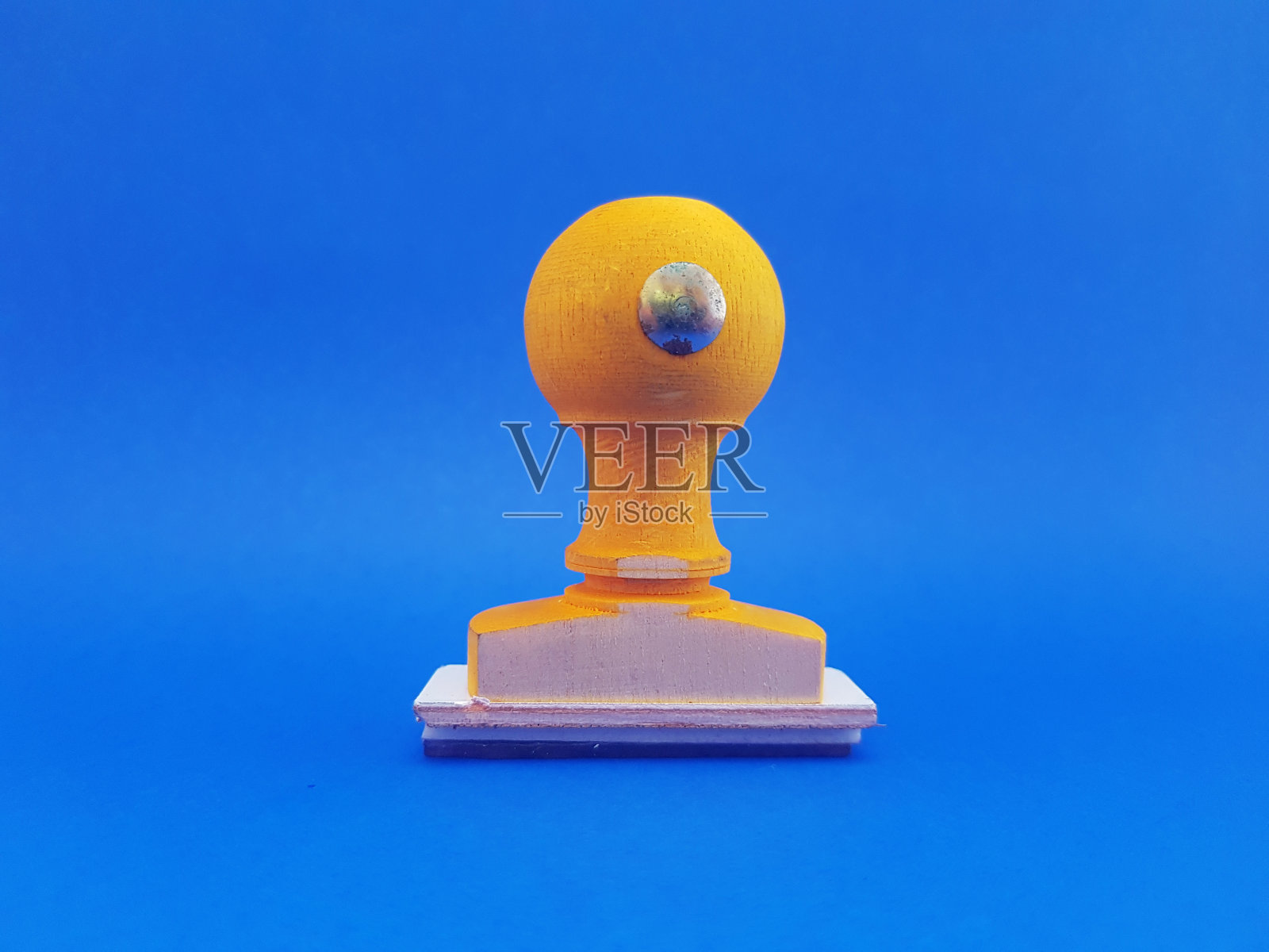 一枚旧的手工邮票,由木头和蓝色背景上的黄色制成照片摄影图片