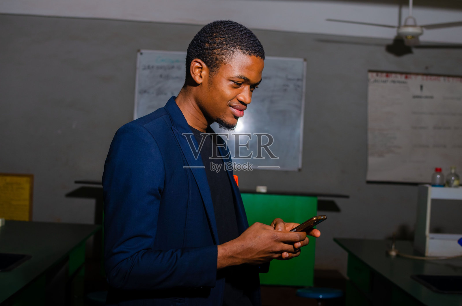 一名非洲男子对他在智能手机上看到的东西微笑照片摄影图片