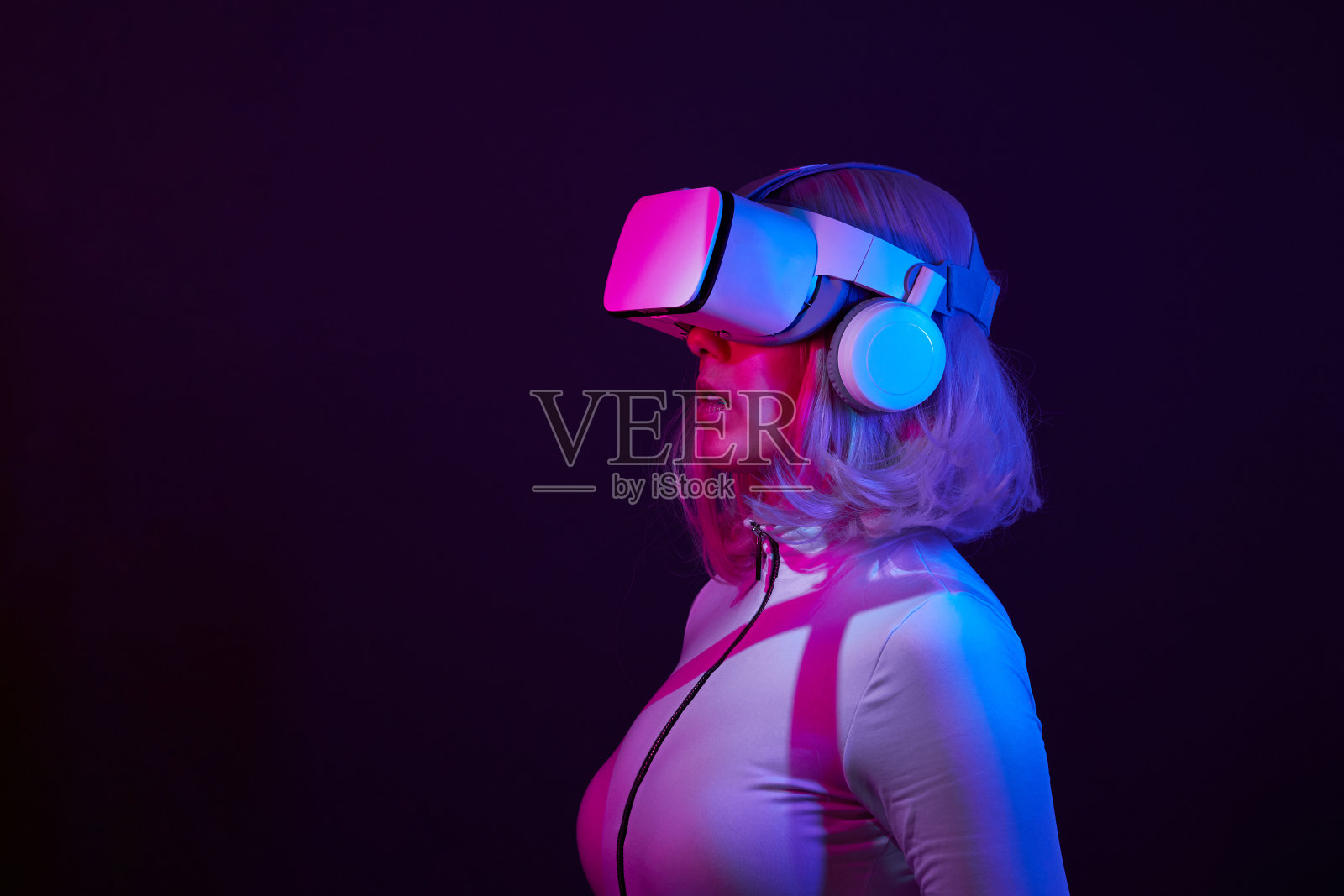 女人在虚拟现实的霓虹灯颜色的护目镜。照片摄影图片