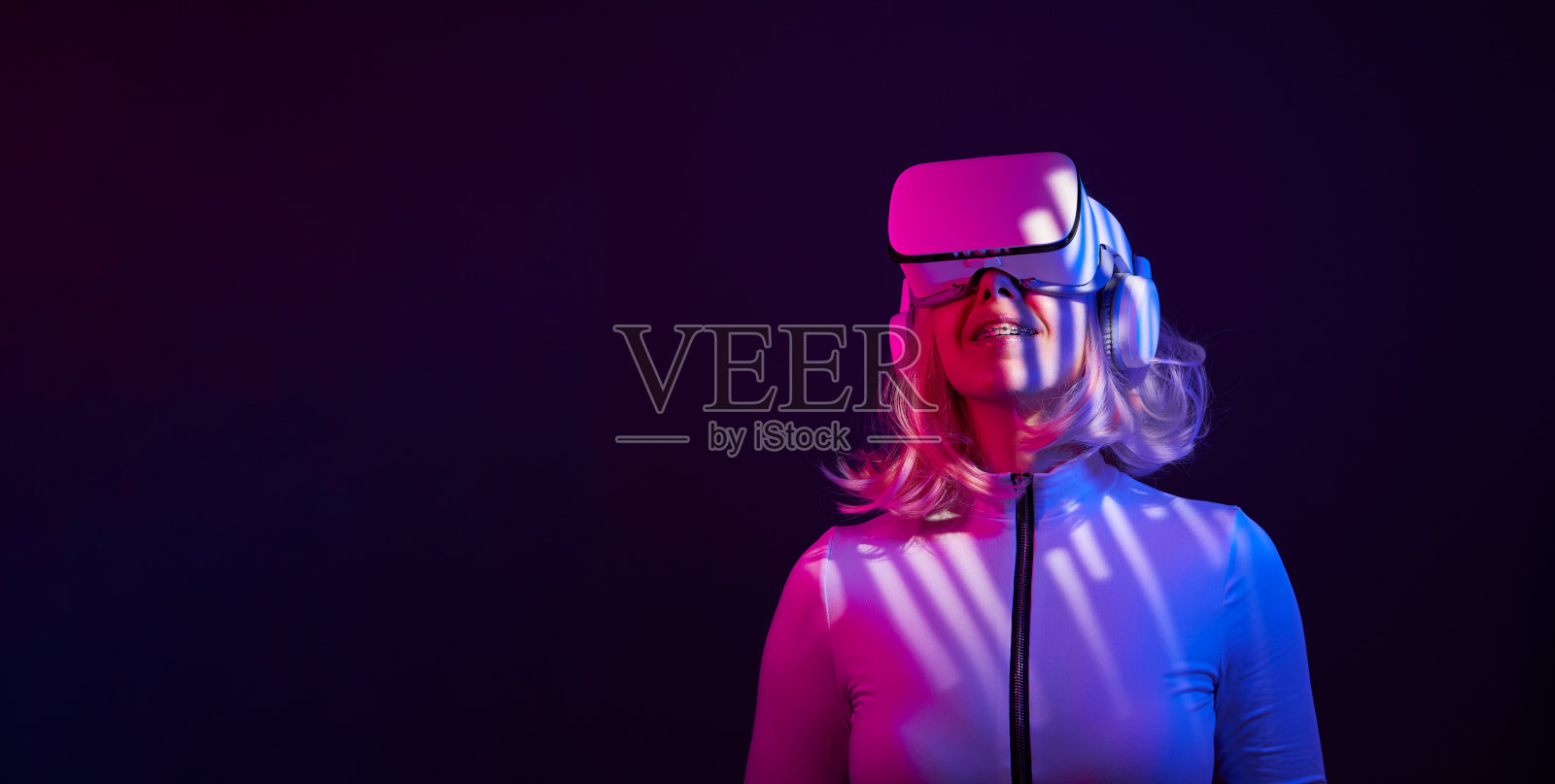 女人在虚拟现实的霓虹灯颜色的护目镜。照片摄影图片