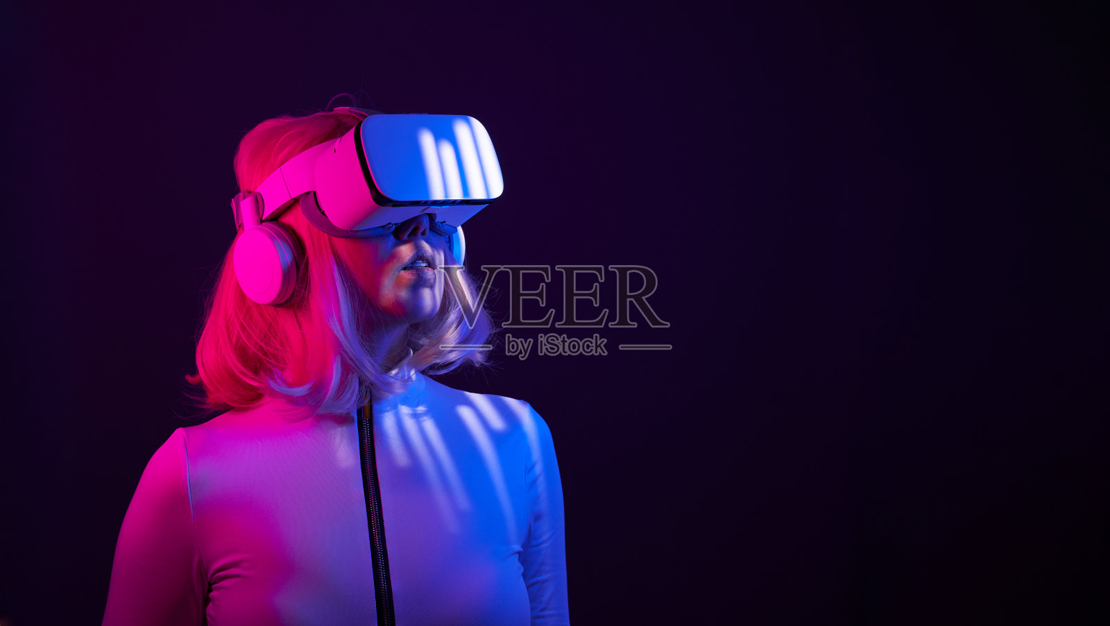 女人在虚拟现实的霓虹灯颜色的护目镜。照片摄影图片