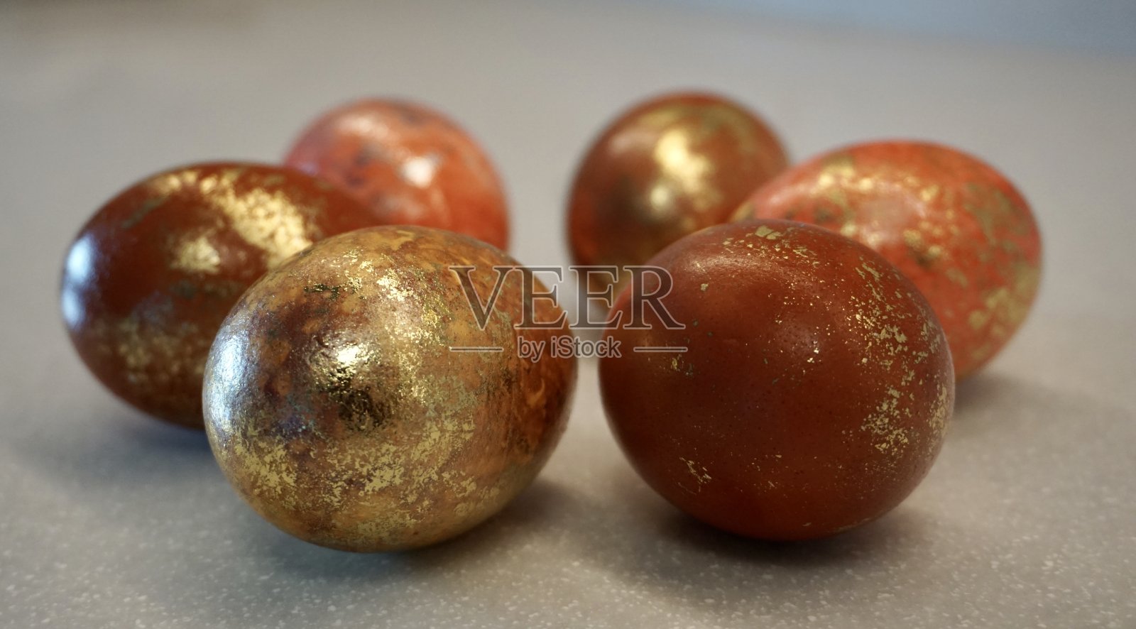 用自然的颜色给复活节彩蛋上色的各种方法。棕色是复活节彩蛋的自然色调。用金箔胶把鸡蛋涂成自然的颜色。用金箔给复活节彩蛋上色的技巧。照片摄影图片