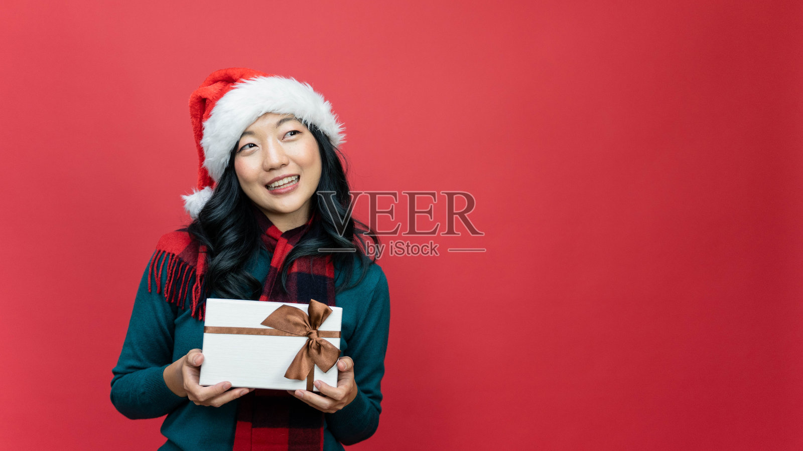 女人拿着礼品盒高兴。祝你生日快乐,妇女节快乐,圣诞节快乐。照片摄影图片