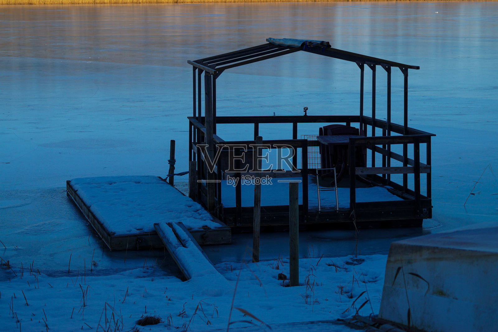 冰湖上码头上的浮船照片摄影图片