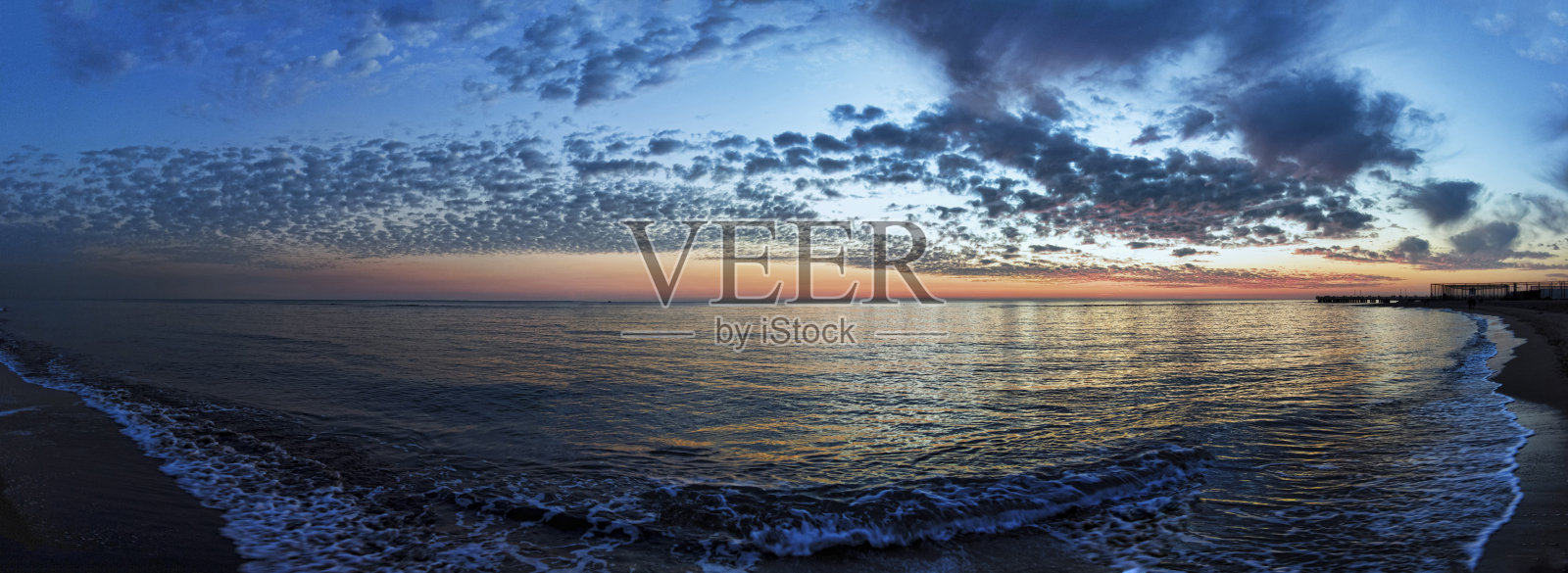 在海滩上的日落时分,美妙而不可错过的蓝色时光,梦幻般的天空,卷积云在苍穹上荡漾,浪漫的气氛中,美妙的金色光线反射在海水上照片摄影图片