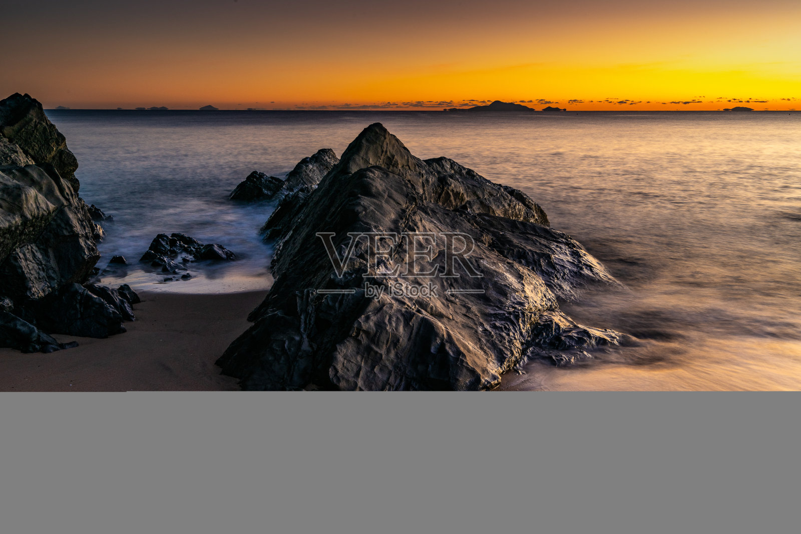海滩上的大岩石和日落的美丽景色照片摄影图片