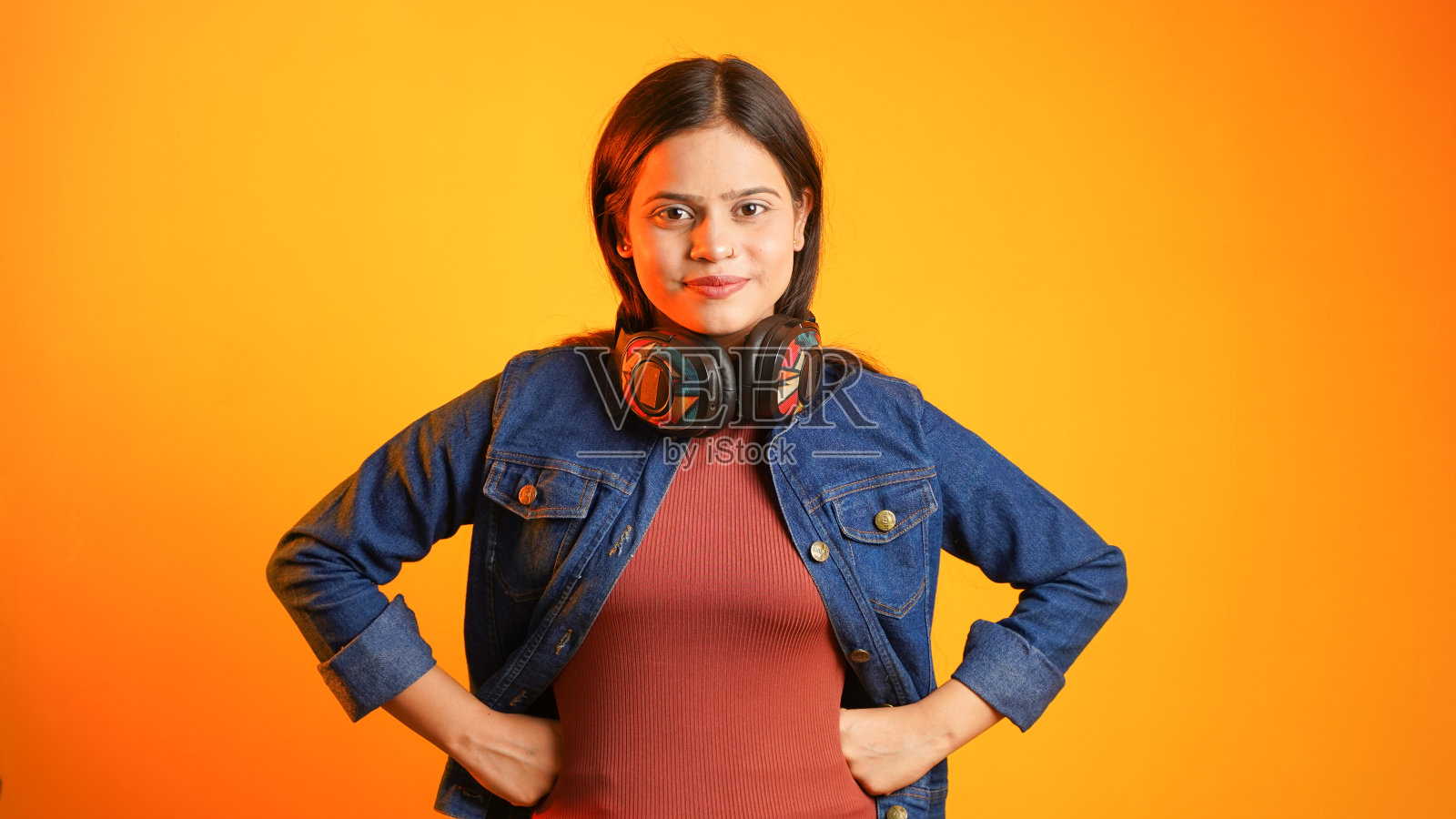 美丽的年轻女子听音乐与无线耳机在她的头上,快乐的少女享受音乐孤立的色彩背景照片摄影图片