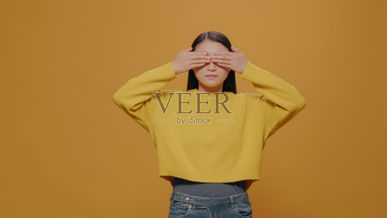 亚洲妇女在工作室里遮住嘴、眼睛和耳朵照片摄影图片