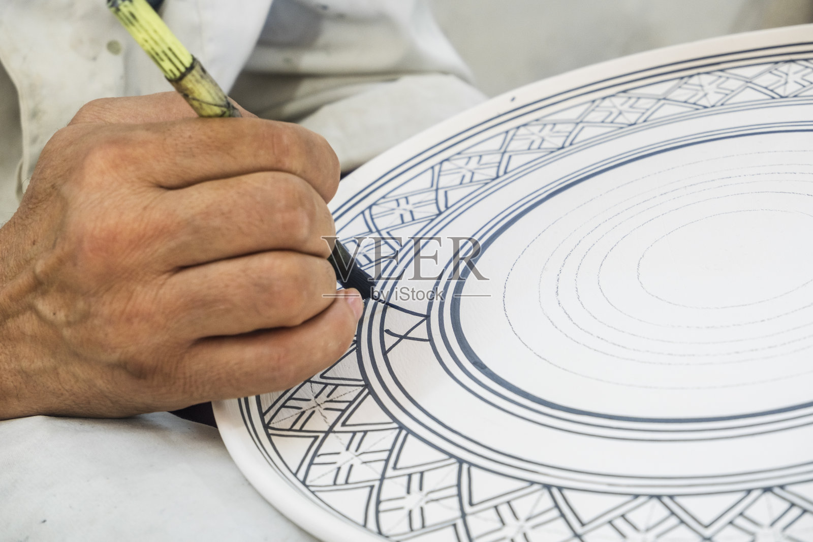 在摩洛哥非斯的陶瓷厂,工匠们在陶瓷制品上作画和装饰。照片摄影图片