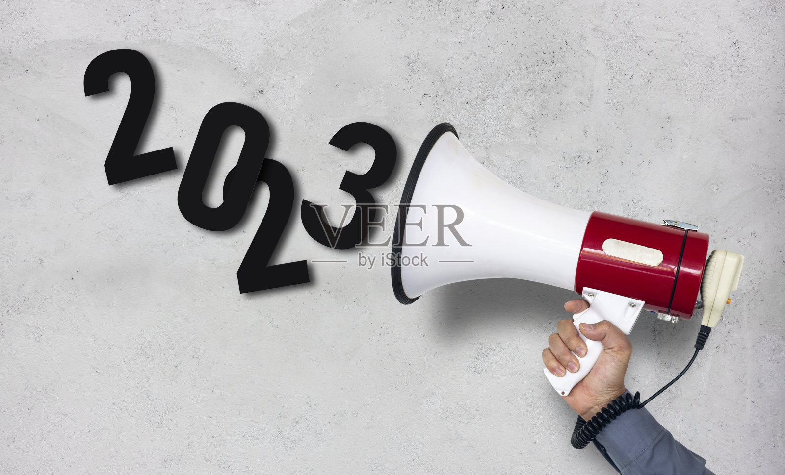 宣布2023年业务计划。一个商人拿着扩音器的特写手。2023年新年快乐。照片摄影图片