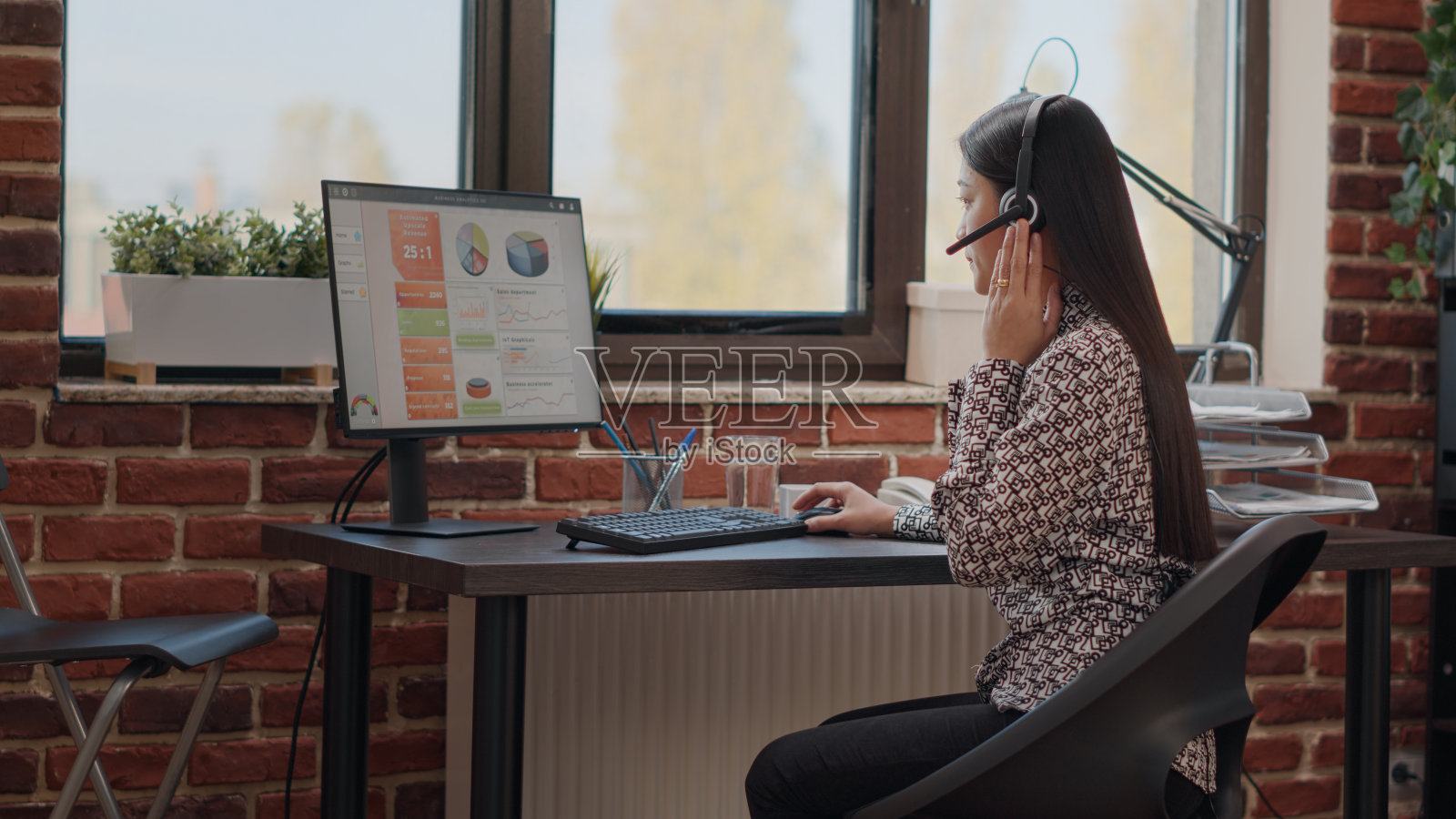 戴着耳机给客户打电话的人照片摄影图片