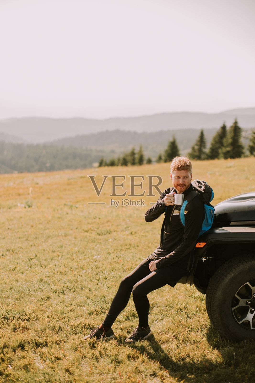 年轻人放松和喝咖啡的地形车引擎盖在农村照片摄影图片