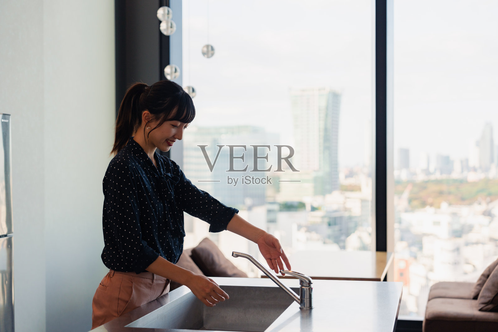 在塔楼公寓的样板间里,一位女士正在检查厨房照片摄影图片