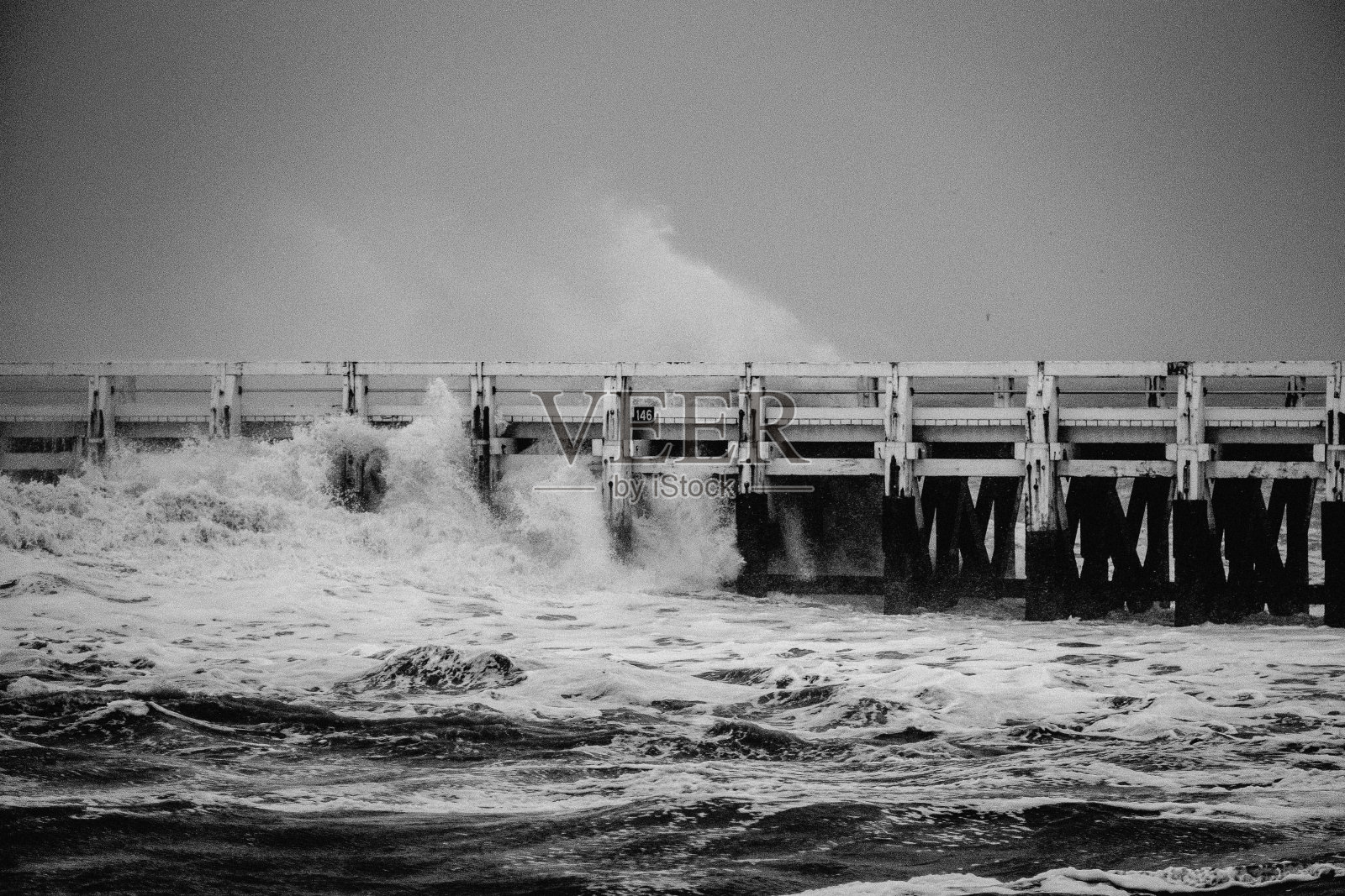 水波打在栅栏上的黑白视图照片摄影图片