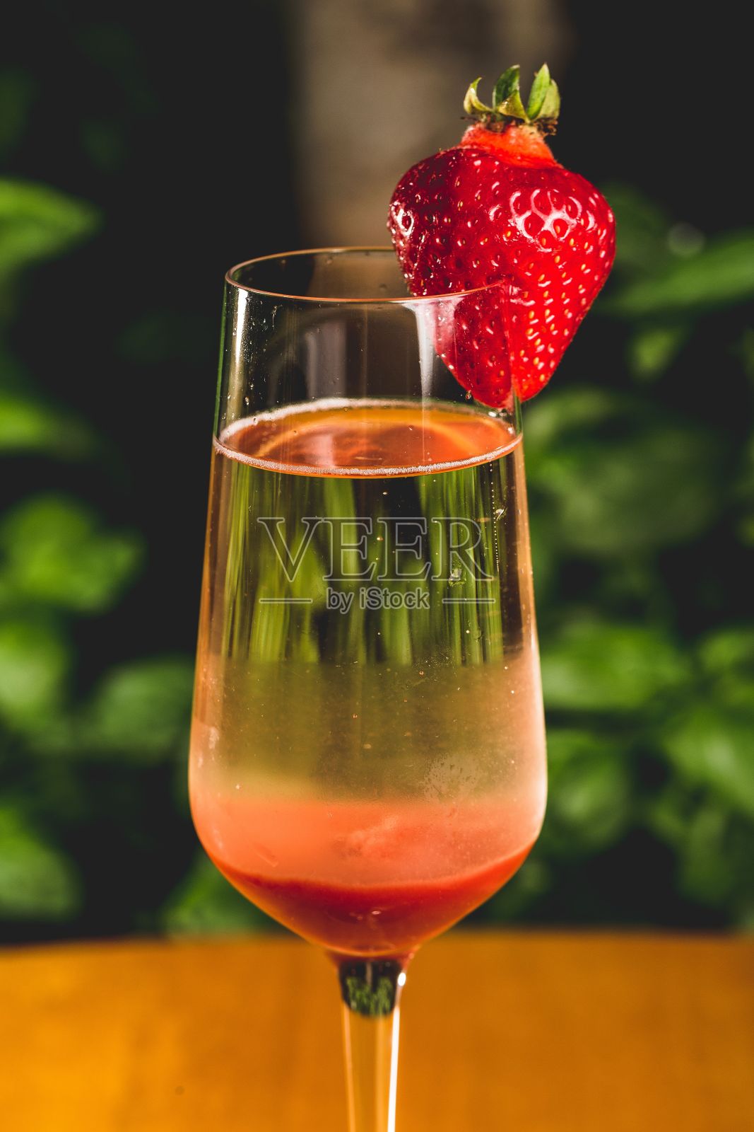 用草莓装饰的玻璃杯中的果汁的垂直特写照片摄影图片